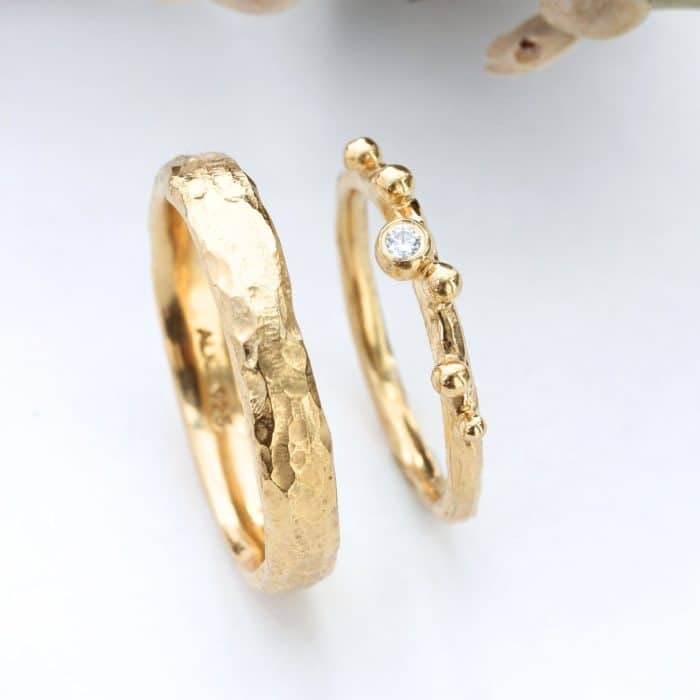 smukke håndlavede lærkegrens vielsesringe i guld med grov fræset overflade set lidt fra siden