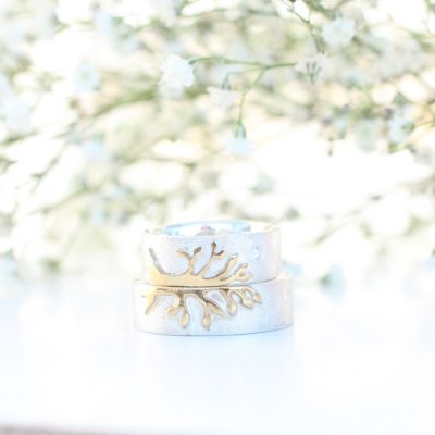Vielsesringe i hvidguld, hvor der er et halvt træ af guld på hver ring.