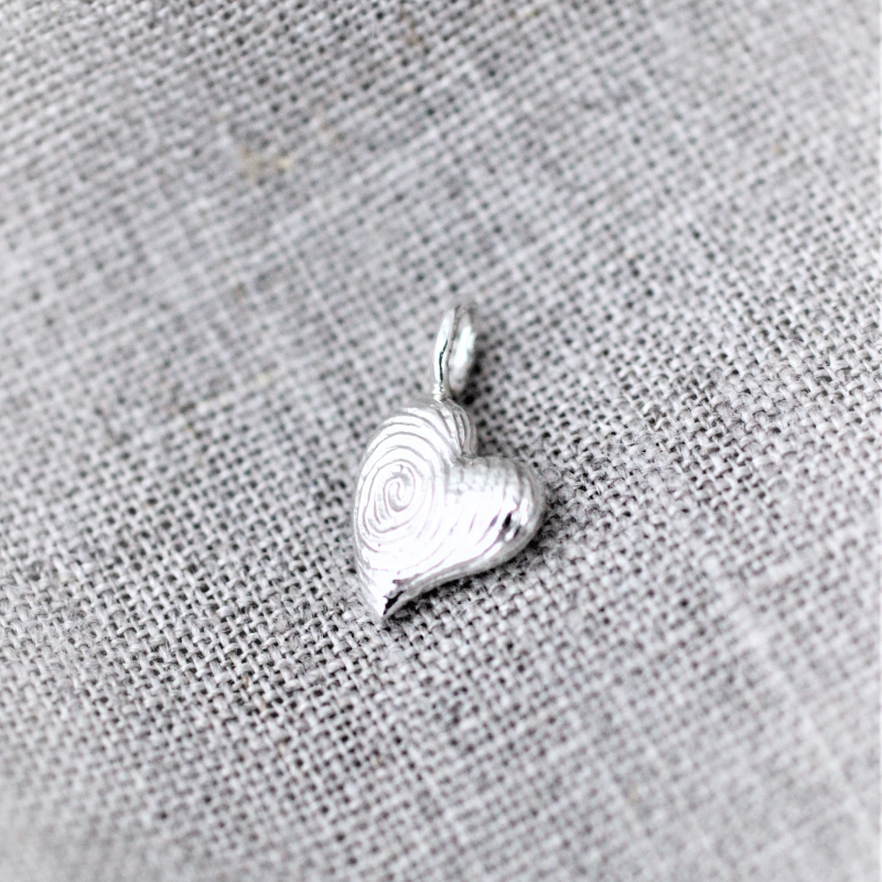 Hjertevedhæng lavet af kundens gamle sølvsmykker og med fingeraftryksmønster