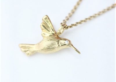 kolibri vedhæng i 14 kt. guld med diamanter som nøjne set her på kæde