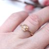guldring med høstanemone og diamant på finger