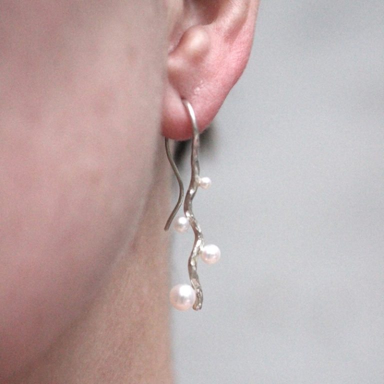 bølgende ørebøjler i sølv med perler på model